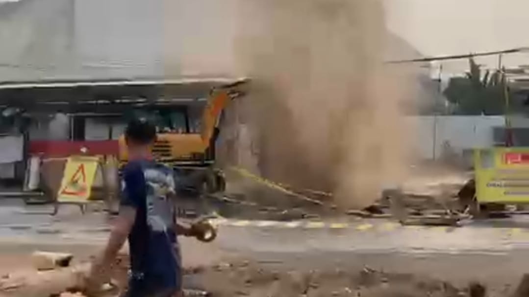 TERKENA ALAT BERAT, SEMBURAN AIR DAN LUMPUR KELUAR DI PERTIGAAN JALAN GRAND MALL BEKASI